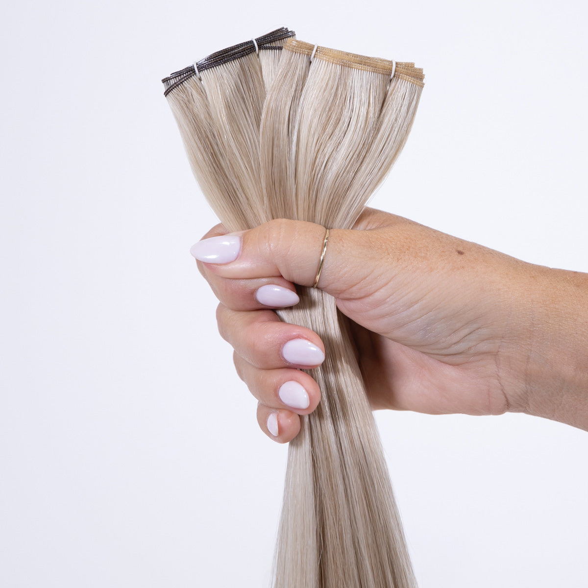 Genius Weft hair extensions held to show the weft construction and colour blend