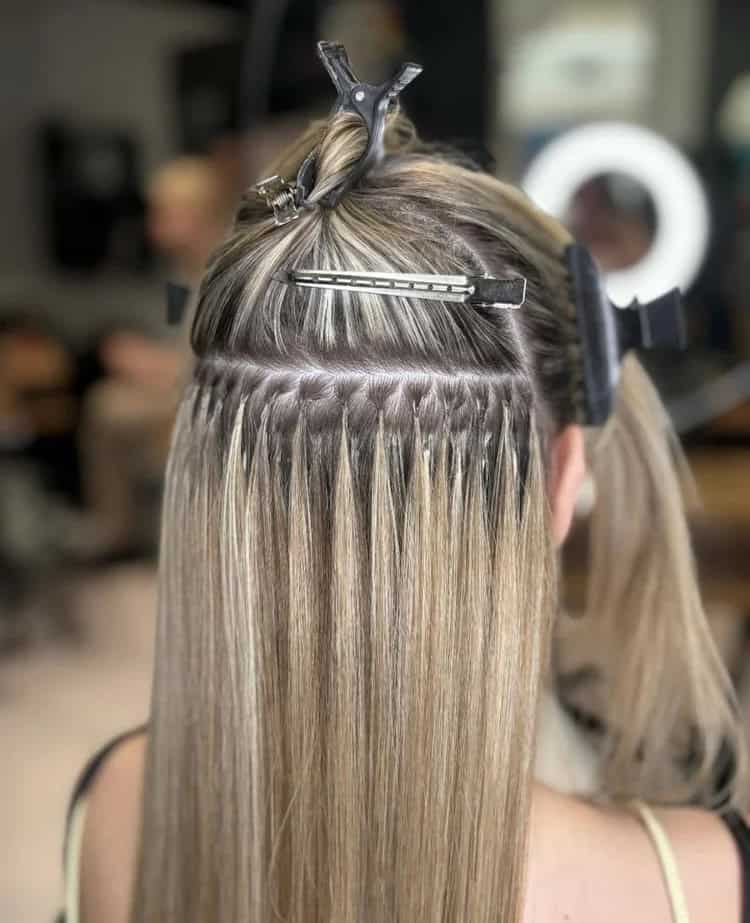 K-tip strands applied strand-by-strand in a salon setting