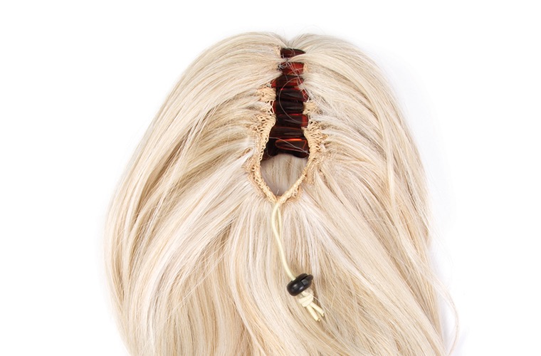 Detailed view of the synthetic ponytail attachment opening and claw clip